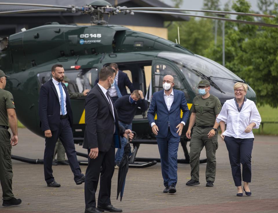 European Council President Charles Michel, center, and Lithuania's Prime Minister Ingrida Simonyte, right, arrive at the place of the Lithuania State Border Guard on the Lithuanian-Belarusian border, near the village Padvarionys, some 40km (24 miles) east of the capital Vilnius, Lithuania, Tuesday, July 6, 2021. (AP Photo/Mindaugas Kulbis)