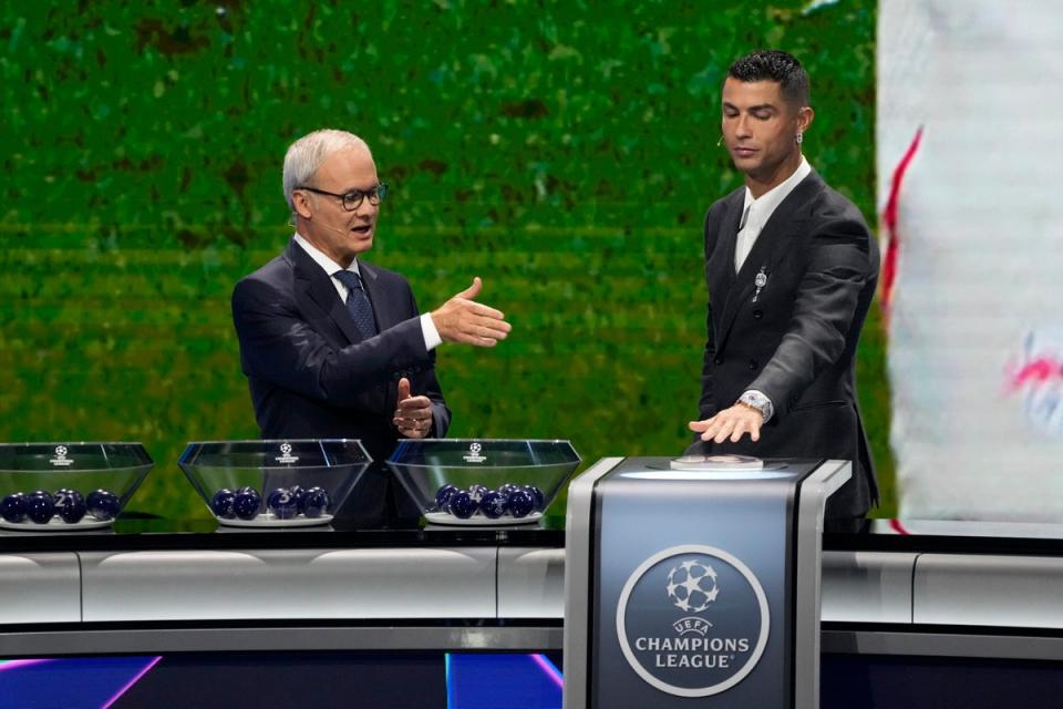 Cristiano Ronaldo had fun pushing a big button to trigger the draw (AP)