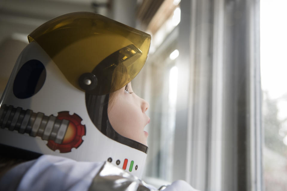 Little girl wearing a space helmet.