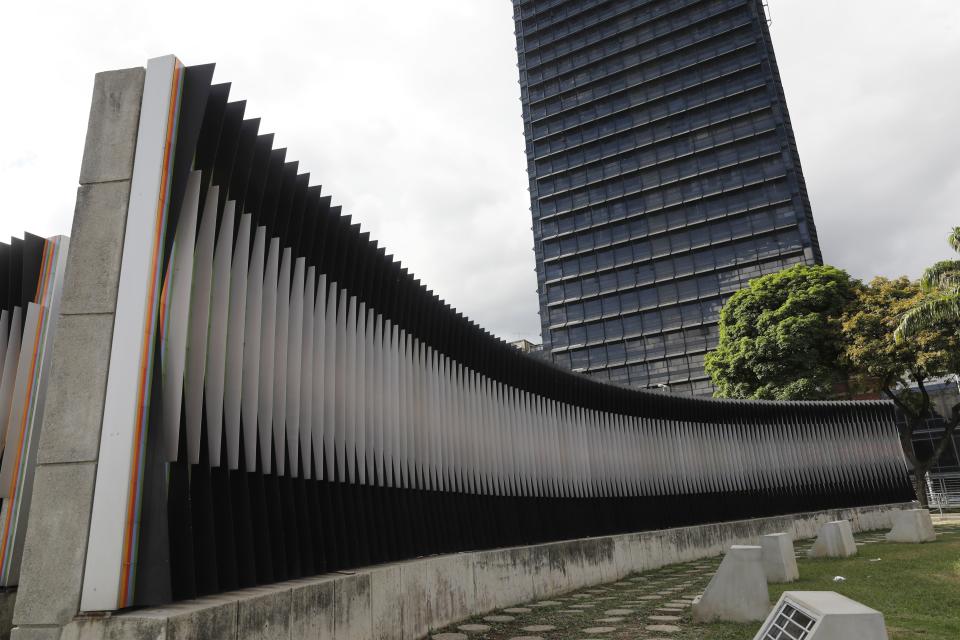 The masterpiece Fisicromía Concavo-Convexa, by Venezuela's master of kinetic art Carlos Cruz-Diez, stands in Caracas' Plaza Venezuela, Venezuela, Tuesday, July 30, 2019. As the art world mourns the death of Cruz-Diez, in his home country many of his urban works are deteriorating and disintegrating, even as the government pays lip service to his art. (AP Photo/Ariana Cubillos)