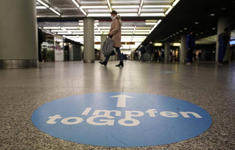 A sign on the floor shows the way to a coronavirus vaccination center in a subway station in Duesseldorf, Germany, Monday, Dec. 6, 2021. Slogan reads: 'vaccination to go'. (AP Photo/Martin Meissner)
