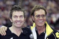 BIRMINGHAM, ENGLAND - DECEMBER 18: Sir Cliff Richard and actor Bradley Walsh take part in the "Intelligent Finance Cliff Richard Tennis Classic" at Birmingham National Indoor Arena on December 18, 2004 in Birmingham, England. The annual tournament raises money for the Cliff Richard Tennis Foundation, which introduces children across the country to the game. (Photo by MJ Kim/Getty Images)
