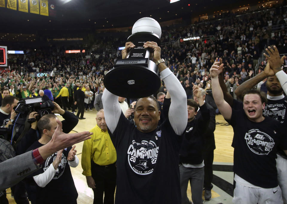 Providence head coach Ed Cooley raises the trophy after winning the Big East regular season title following an NCAA college basketball game against Creighton, Saturday, Feb. 26, 2022, in Providence, R.I. (AP Photo/Stew Milne)