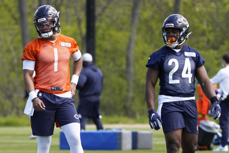 Chicago Bears quarterback Justin Fields (1) and running back Khalil Herbert (24) participate in drills during the NFL football team's rookie minicamp Friday, May, 14, 2021, in Lake Forest Ill. (AP Photo/David Banks, Pool)