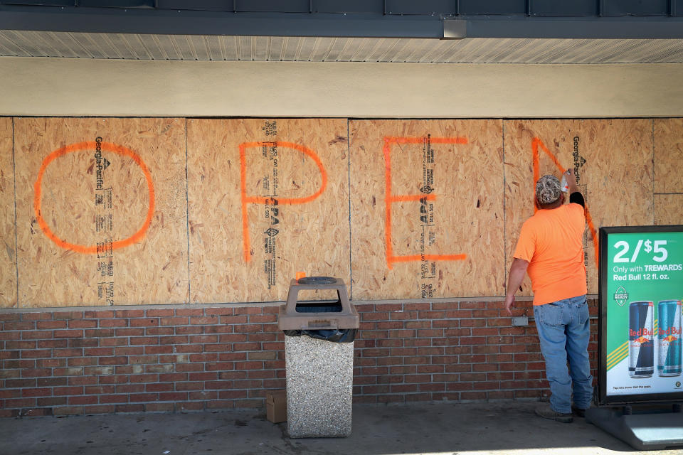 A man boards up the windows of his store in Florida in preparation for Hurricane Dorian (Picture: Getty)