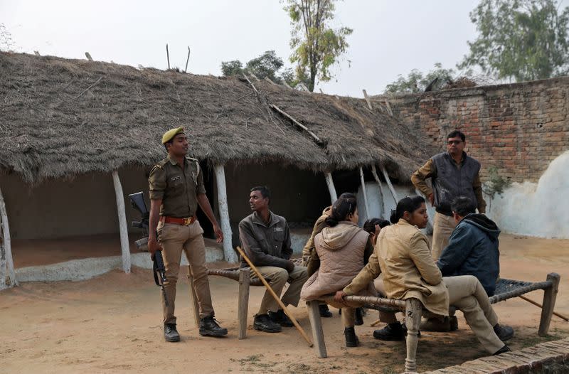 Members of police are seen near the house of a 23-year-old rape victim, who died in a New Delhi hospital