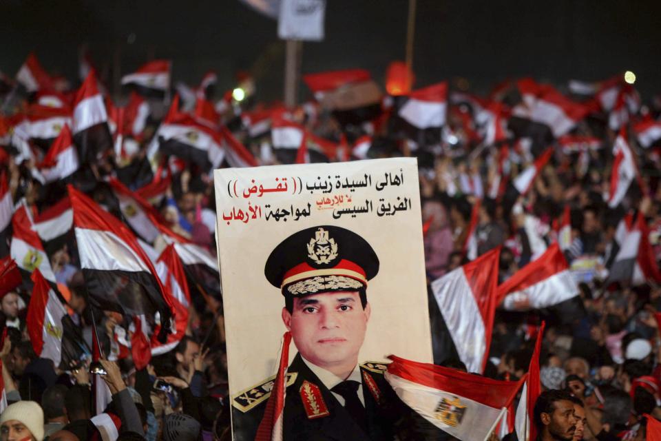 Supporters of Egypt's army chief General Abdel Fattah al-Sisi holds a poster of Sisi in Tahrir square in Cairo, on the third anniversary of Egypt's uprising, January 25, 2014. Twenty-nine people were killed during anti-government marches on Saturday while thousands rallied in support of the army-led authorities, underlining Egypt's volatile political fissures three years after the fall of autocrat President Hosni Mubarak. Security forces lobbed teargas and some fired automatic weapons in the air to try to prevent demonstrators opposed to the government reaching Tahrir Square, the symbolic heart of the 2011 uprising that toppled the former air force commander. (REUTERS/Mohamed Abd El Ghany)