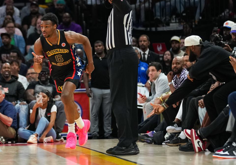 Bronny James reacts after sinking a 3-pointer while LeBron James celebrates.