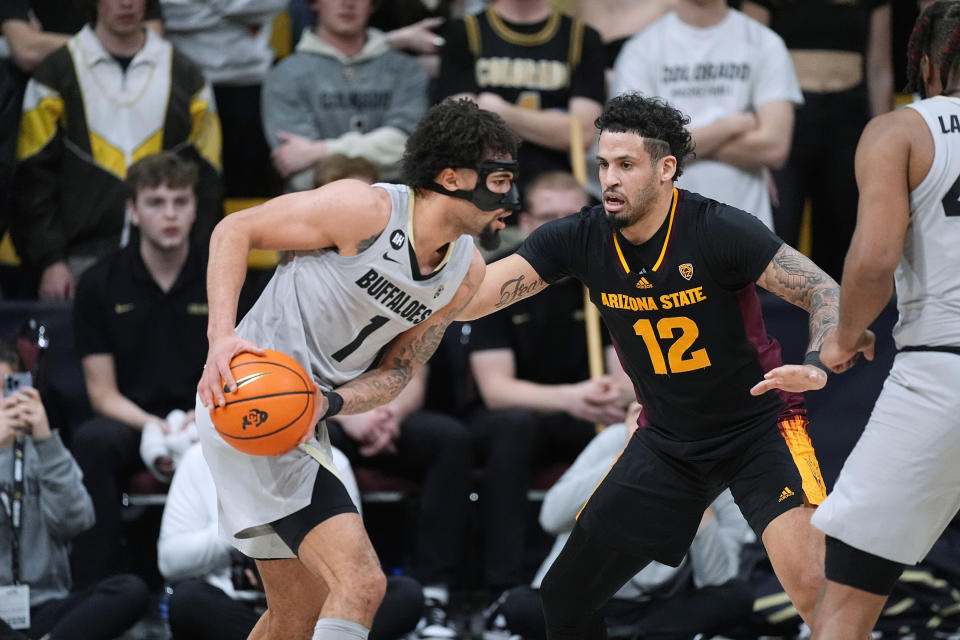 Colorado guard J'Vonne Hadley, left, looks to pass the ball as Arizona State guard Jose Perez defends during the first half of an NCAA college basketball game Thursday, Feb. 8, 2024, in Boulder, Colo. (AP Photo/David Zalubowski)