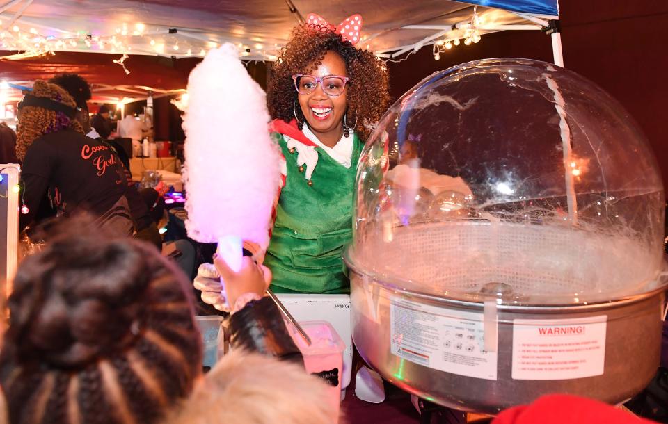 A Dickens of a Christmas is a Victorian holiday event that was held in downtown Spartanburg on Dec. 6. Dani Graham of Spartanburg lights up as she makes candy for kids as part of her candy business for the event. 