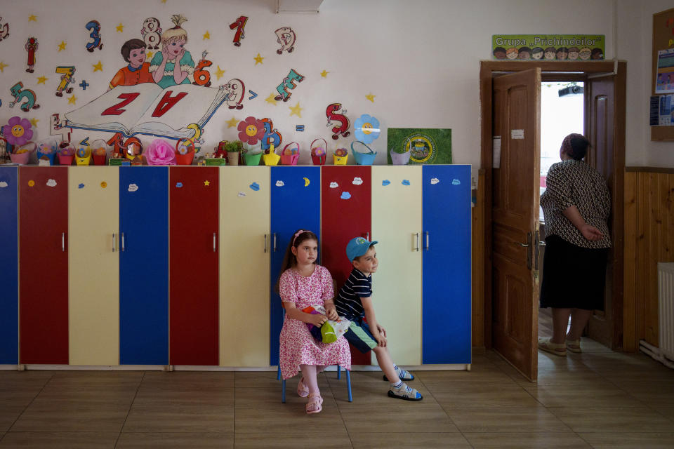 Children wait for their relatives to vote in European Parliament and local elections in Baleni, Romania, Sunday, June 9, 2024. Voters across the European Union are going to the polls on the final day of voting for the European parliamentary elections to choose their representatives for the next five-year term. (AP Photo/Vadim Ghirda)