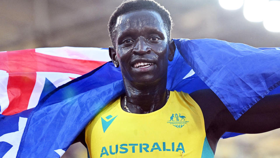 Peter Bol drapes the Australian Flag over his shoulders after winning silver in the 800m at the 2022 Commonwealth Games.