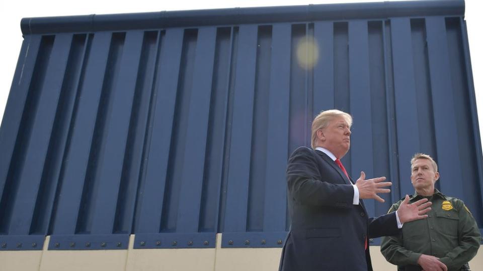 Donald Trump junto a un trozo de muro fronterizo.