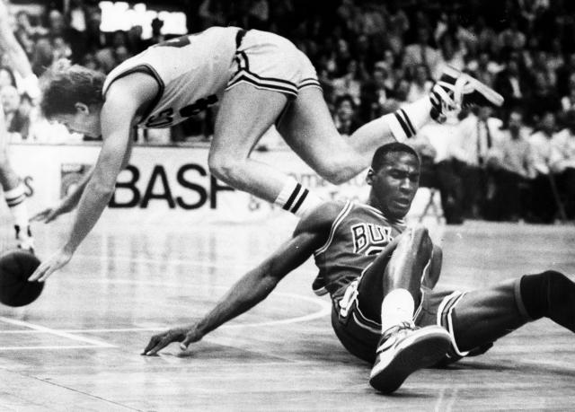 BOSTON: El jugador de los Boston Celtics Danny Ainge y el jugador de los Chicago Bulls Michael Jordan, caen durante el juego de la primera ronda de los playoffs de la Conferencia del Este en el Boston Garden en Boston el 17 de abril de 1986. (Foto de Bill Brett/The Boston Globe via Getty Images)