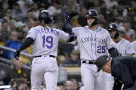 Colorado Rockies' Charlie Blackmon, left, gets congratulations from C.J. Cron after hitting a two-run home run against the San Diego Padres during the fifth inning of a baseball game in San Diego, Friday, March 31, 2023. (AP Photo/Alex Gallardo)