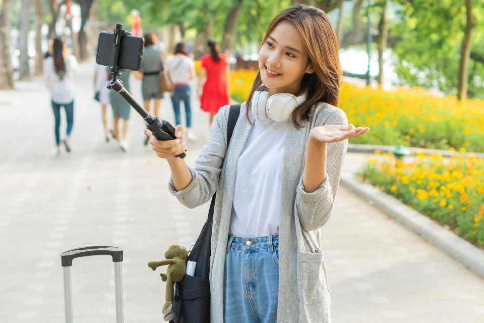 Asian woman recording video on the street in Hanoi, Vietnam