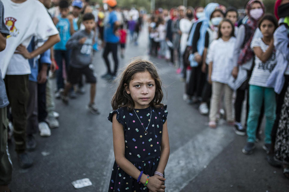 2020年9月10日，一個女孩在被燒毀的莫里亞難民營附近排隊買飯。 