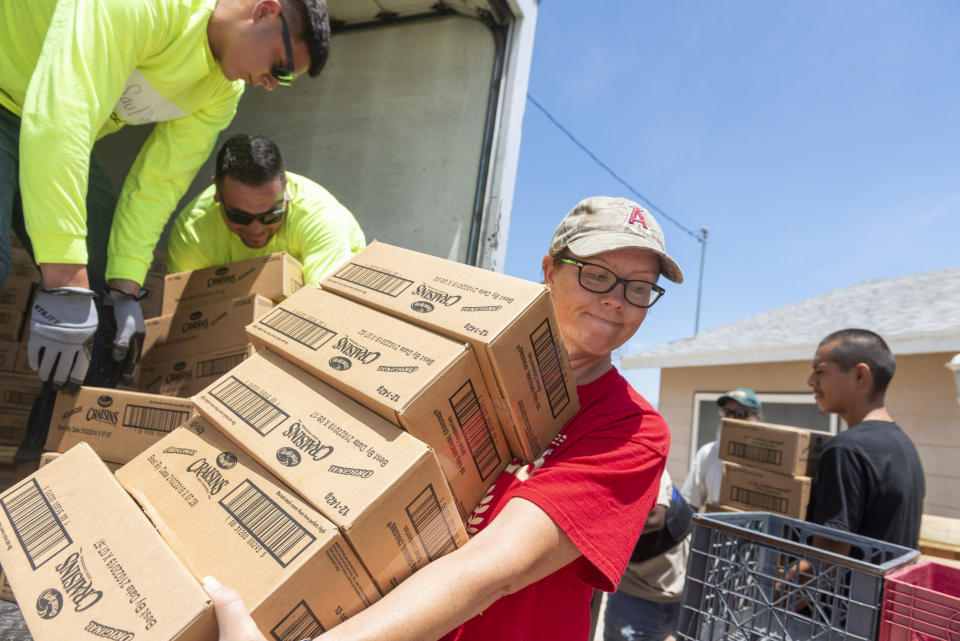 Bobbie Pitman of the Christian Fellowship of Trona, Calif., helps unload a truck from Desert Manna on Tuesday July 9, 2019, in Trona, Calif. Charities and governmental agencies ramped up recovery efforts in the small town ravaged by earthquakes and aftershocks. It could be several more days before water service is restored to the tiny town of Trona, where officials trucked in portable toilets and showers. (James Quigg/The Daily Press via AP)