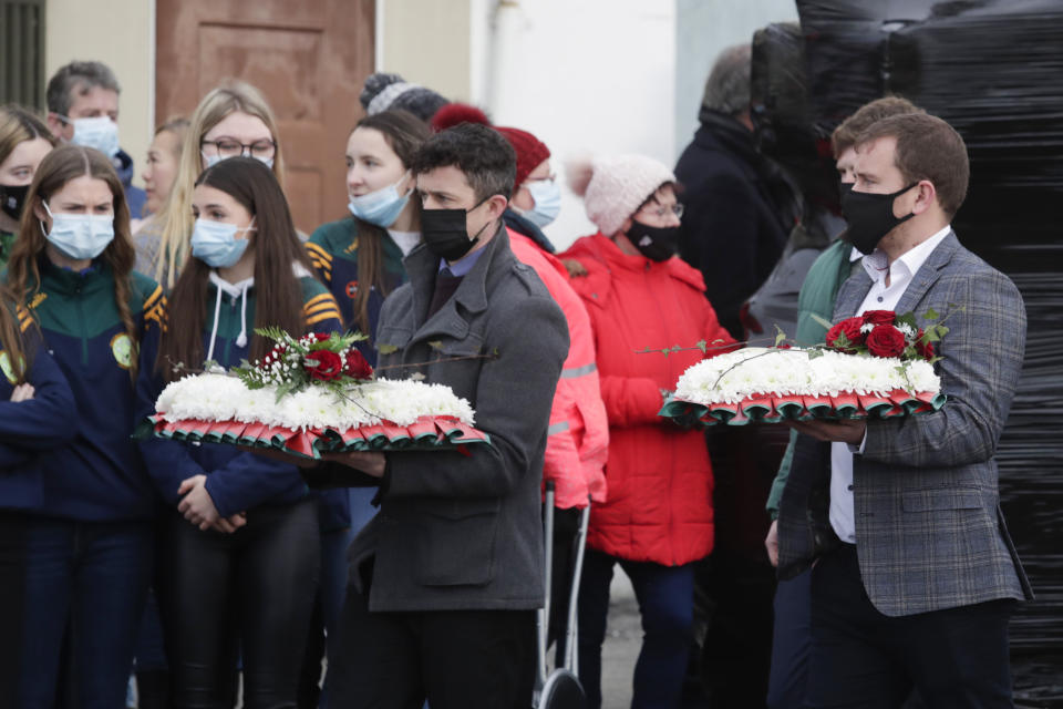 Mourners arrive with flowers at St Brigid's Church, Mountbolus, Co Offaly, for the funeral of Ashling Murphy, who was murdered in Tullamore, Co Offaly last Wedensday. 23-year-old Ashling, a primary school teacher and a talented musician, was found dead after going for a run on the banks of the Grand Canal in Tullamore. Picture date: Tuesday January 18, 2022.