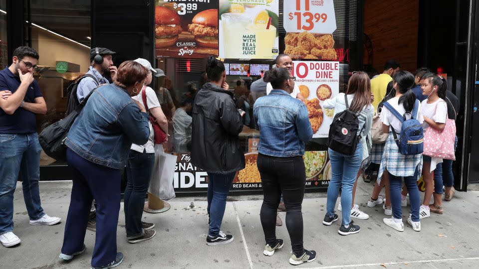 People wait in line outside a Popeyes Louisiana Kitchen in New York City in 2019. - Shannon Stapleton/Reuters