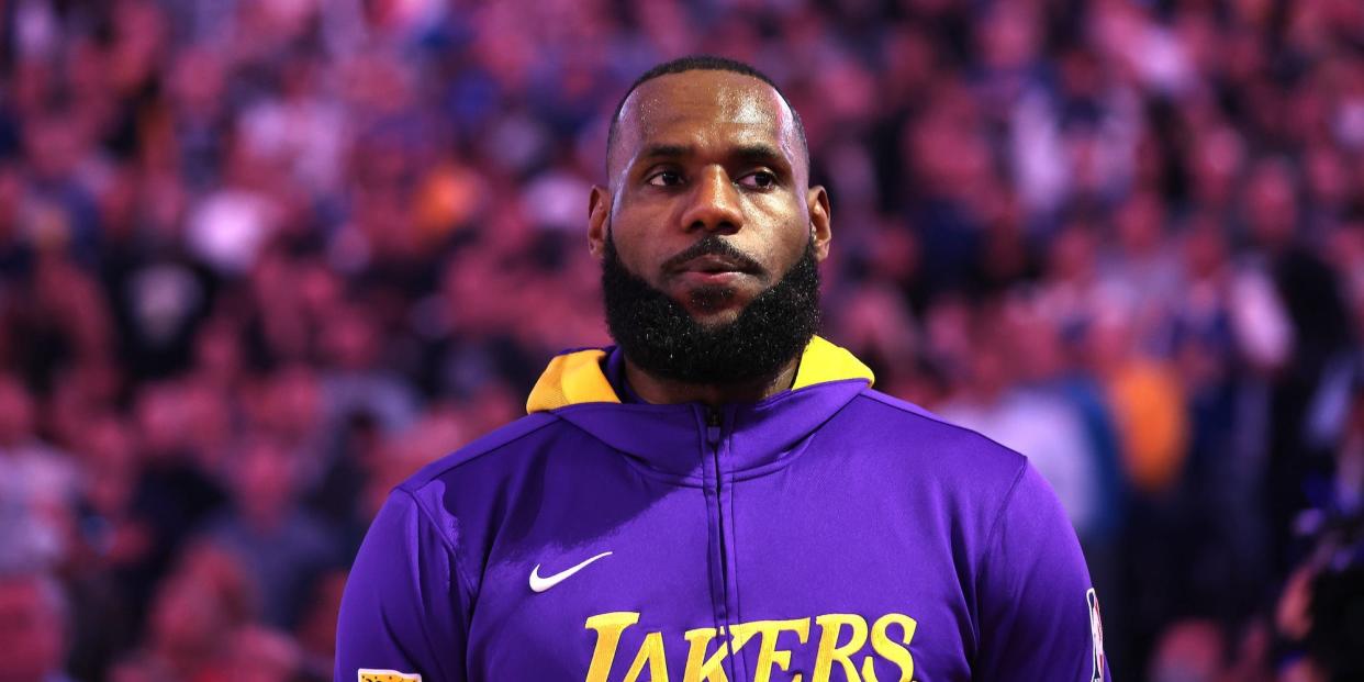 LeBron James looks on while wearing Lakers warmups before a game.