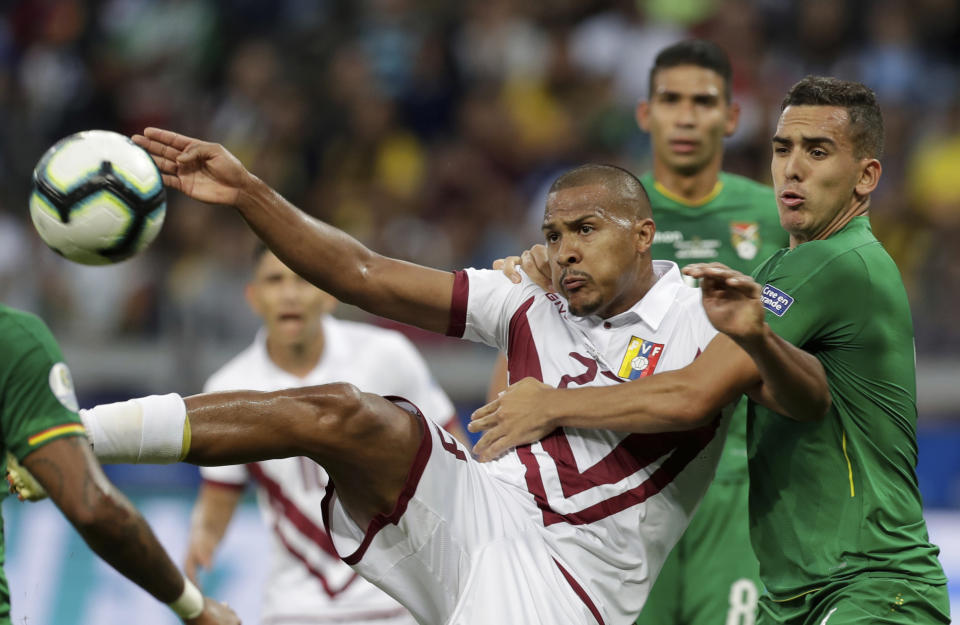 Venezuela's Salomon Rondon, left, fights for the ball with Bolivia's Marvin Bejarano during a Copa America Group A soccer match at Mineirao stadium in Belo Horizonte, Brazil, Saturday, June 22, 2019. Venezuela won the match 3-1 and advances to the quarter finals. (AP Photo/Eraldo Peres)