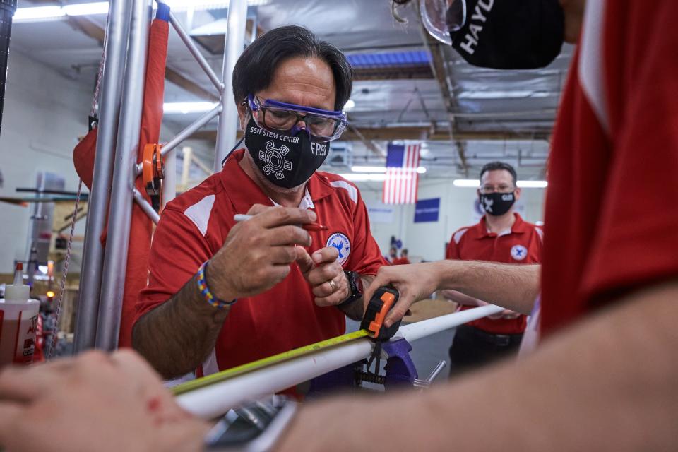 Faridodin “Fredi” Lajvardi,  vice president of STEM initiatives at Si Se Puede and coach/manager for Degrees of Freedom, marks where to cut on a PVC pipe at Si Se Puede Foundation STEM Center in Chandler on April 13, 2022. The PVC pipe is being used to construct a team pit at the world championships in Houston.