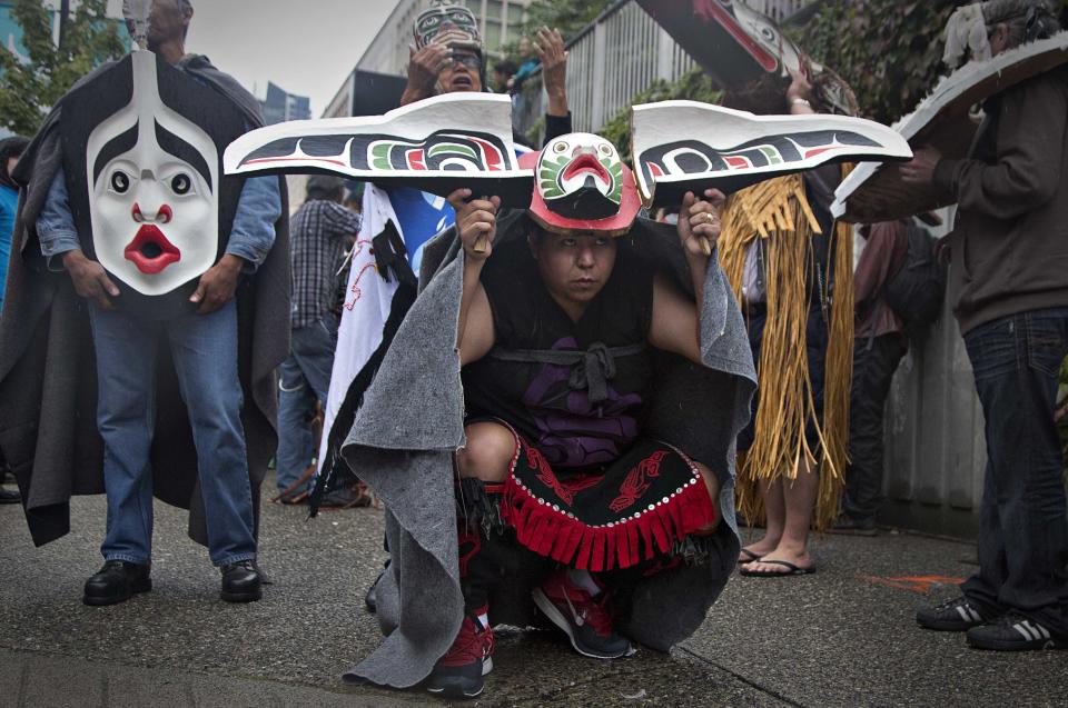 First Nations' participants whear traditional masks while waiting to take part in a Truth and Reconciliation march in Vancouver