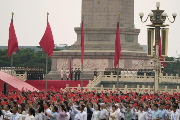 Communist Party members waving flags in Tiananmen Square
