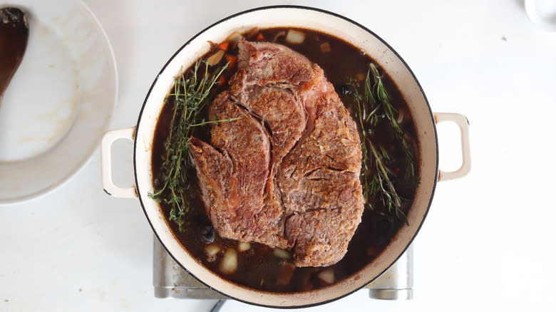 chuck roast and herbs in liquid