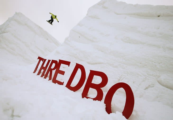 Snowboarder jumps between two large mounds