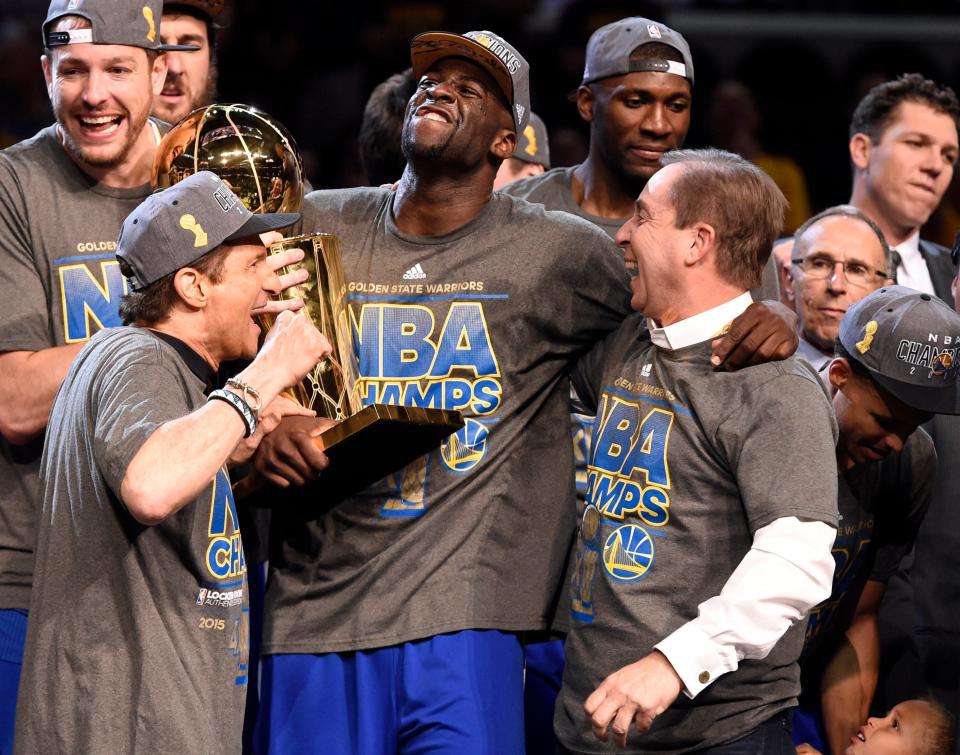 Draymond Green (23) celebrates Golden State's 2015 NBA title with team owners Peter Guber (left) and Joe Lacob (right).