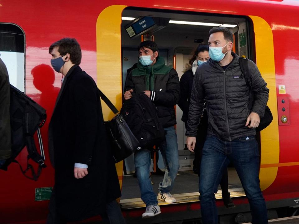 Commuters with face coverings leave a London underground train (AFP/Getty)