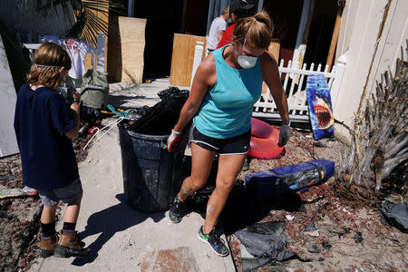 People clean up their house that was destroyed following Hurricane Michael in Mexico Beach, Florida, U.S., October 13, 2018. REUTERS/Carlo Allegri