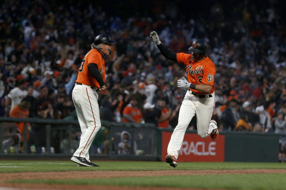 San Francisco Giants' Curt Casali, right, is congratulated by third base coach Ron Wotus after hitting a solo home run against the Oakland Athletics during the seventh inning of a baseball game in San Francisco, Friday, June 25, 2021. (AP Photo/Jed Jacobsohn)