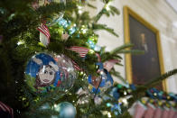 Ornaments containing self-portraits of students from across the country hang from a tree in the State Dining Room of the White House during a press preview of holiday decorations at the White House, Monday, Nov. 28, 2022, in Washington. (AP Photo/Patrick Semansky)
