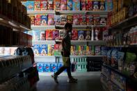 A children passes in front of a shelf with cereal boxes at a "bodegon" named "Mini Walmart" in Puerto Cabello