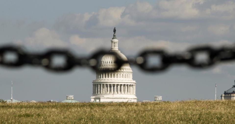 REFILE - QUALITY REPEAT The U.S. Capitol is photographed behind a chain fence in Washington September 30, 2013. As many as a million government employees were making urgent plans on Monday for a possible midnight shutdown, with their unions urging Congress to strike a last-minute deal. REUTERS/Kevin Lamarque (UNITED STATES - Tags: POLITICS BUSINESS TPX IMAGES OF THE DAY)