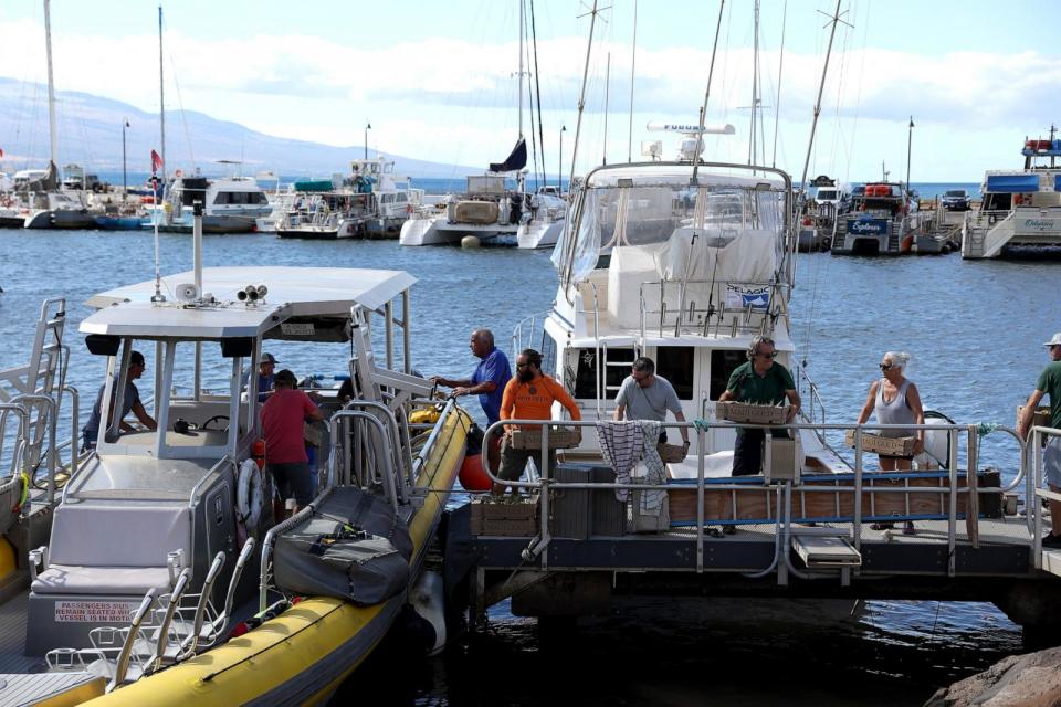 PHOTO: In this Aug. 14, 2023, file photo, volunteers load boxes of pineapple onto a boat destined for West Maui in Wailuku, Hawaii.  (Justin Sullivan/Getty Images, FILE)