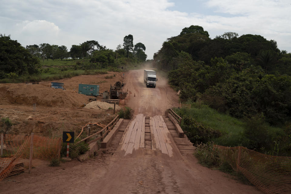 In this Nov. 26, 2019 photo, a truck drives on the road in Ruropolis, Para state, Brazil. From Ruropolis, the Trans-Amazon and BR-163 run jointly westward over a bumpy 70 miles before splitting at a little roundabout. During corn and soy harvests, 2,600 trucks pass through each day to and from the nearby Tapajos river. (AP Photo/Leo Correa)