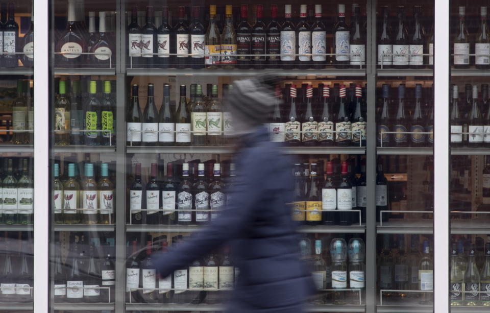 A person walks past shelves of bottles of alcohol on display at an LCBO in Ottawa, Thursday March 19, 2020. THE CANADIAN PRESS/Adrian Wyld