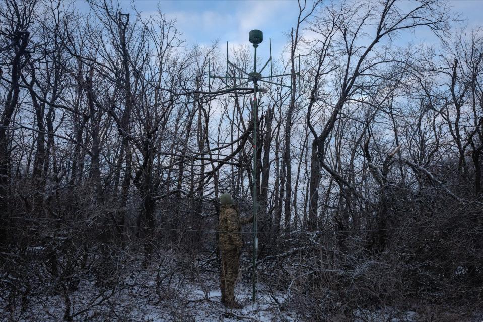 A Ukrainian soldier installs an electronic-warfare system antenna to listen to Russian chatter at the front line near Bakhmut, in the Donetsk region, on Jan. 29, 2024.