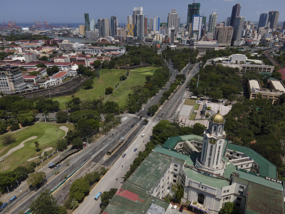 Manila city hall is seen beside an almost empty road as the government implements a strict lockdown to prevent the spread of the coronavirus on Good Friday, April 2, 2021 in Manila, Philippines. Filipinos marked Jesus Christ's crucifixion Friday in one of the most solemn holidays in Asia's largest Catholic nation which combined with a weeklong coronavirus lockdown to empty Manila's streets of crowds and heavy traffic jams. Major highways and roads were eerily quiet on Good Friday and churches were deserted too after religious gatherings were prohibited in metropolitan Manila and four outlying provinces. (AP Photo/Aaron Favila)