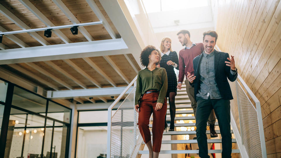 Group of coworkers going down the stairs and talking.