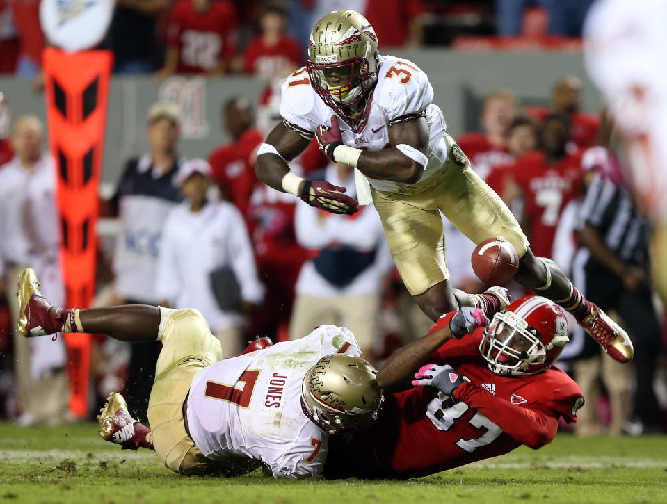 Teammates Terrence Brooks #31 of the Florida State Seminoles and Christian Jones #7 collide with Mario Carter #87 of the North Carolina State Wolfpack during their game at Carter-Finley Stadium on October 6, 2012 in Raleigh, North Carolina. (Photo by Streeter Lecka/Getty Images)