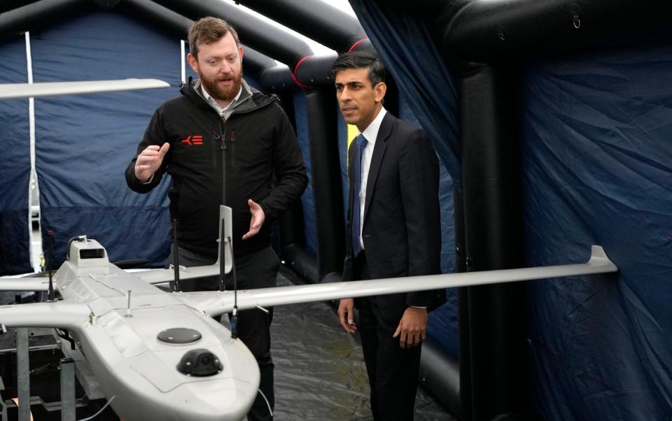 Rishi Sunak, right, speaks with a member of the Home Office contracted staff as he views a drone used for surveillance of vessels in distress during a visit to a Home Office joint control room in Dover, Kent - Kirsty Wigglesworth/AP