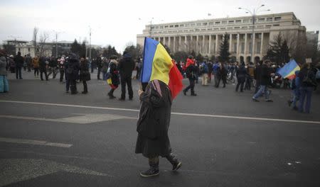 A woman carries a Romanian flag during a demonstration against a cabinet decree passed earlier in the week decriminalising some graft offences, in Bucharest, Romania February 4, 2017. REUTERS/Stoyan Nenov