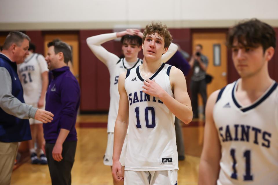 St. Thomas Aquinas freshman AJ Reinertson (10) and senior Liam Lena (11) head off the floor after Wednesday's 62-49 loss to Mascoma in a Division III boys basketball semifinal at Goffstown High School.