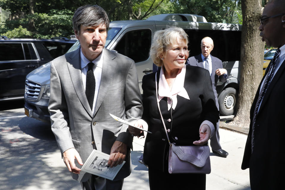 Lucinda Franks, widow of Robert Morgenthau, ex-prosecutor and Manhattan's longest-serving DA who inspired a 'Law & Order' character, is escorted to his funeral at Temple Emanu-El, Thursday, July 25, 2019, in New York. New York Mets owner Fred Wilpon is at background right. (AP Photo/Richard Drew)