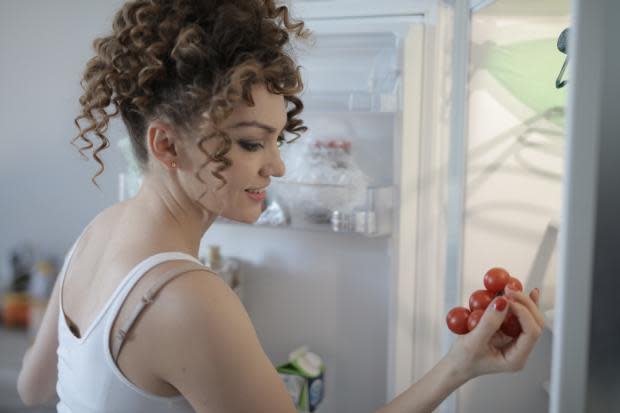 Dorset Echo: A woman putting tomatoes in her fridge. Credit: Canva